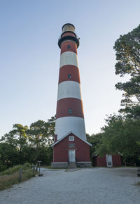 Low angle view of lighthouse by building against sky