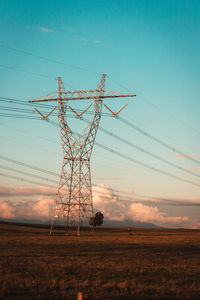 Low angle view of electricity pylon on field against sky