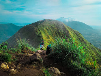 People on mountain against sky