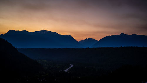 Scenic view of silhouette mountains against sky during sunset