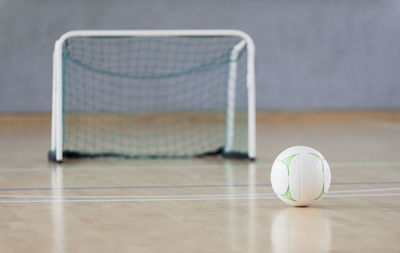 Close-up of soccer ball on hardwood floor at court
