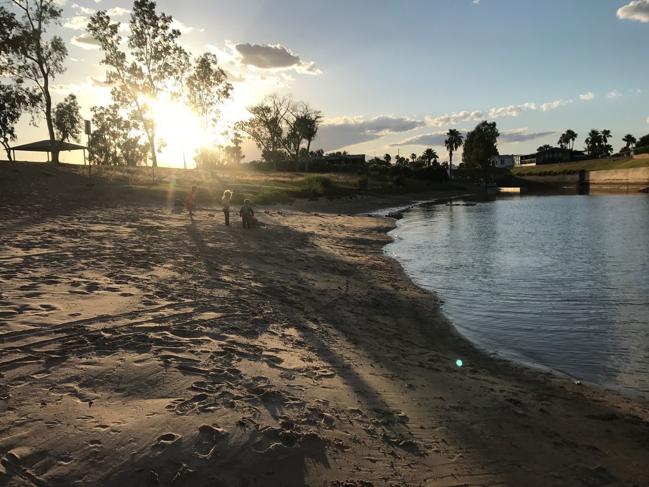 PEOPLE ON BEACH AGAINST SKY DURING SUNSET