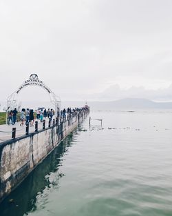 People in sea against sky