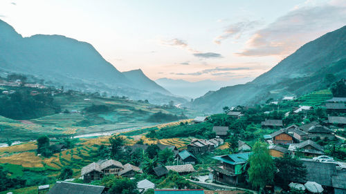 Aerial view of townscape and mountains against sky