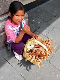 High angle view of girl sitting on street