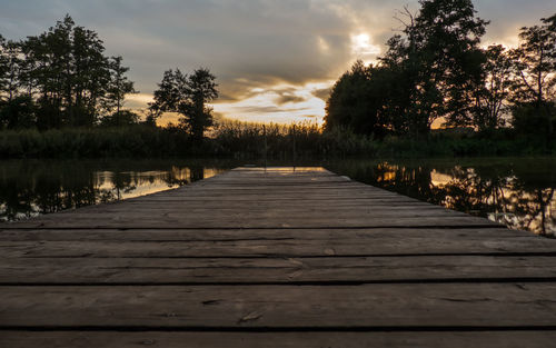 View of pier over lake against sky during sunset