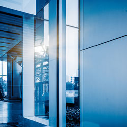 Buildings against blue sky seen through glass window