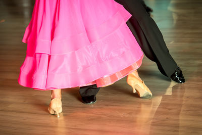 Low section of woman standing on hardwood floor