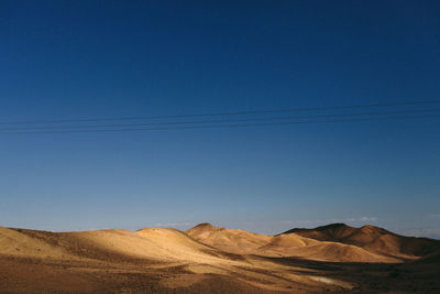 Scenic view of desert against blue sky