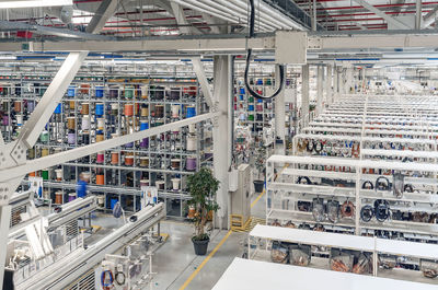 Interior of modern warehouse with coils of colored cable on metal shelves. car wiring plant. 