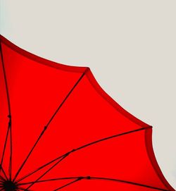 Low angle view of red umbrella against clear sky