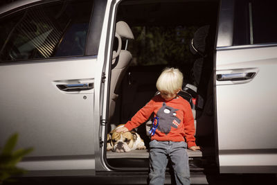 Rear view of woman standing in car