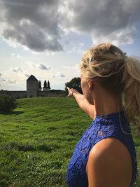 Rear view of woman standing against sky