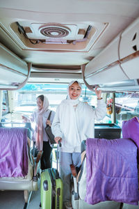 Portrait of female friends sitting in bus