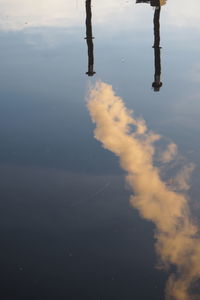 Reflection of smoke stack on lake