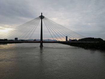 Suspension bridge over river against sky