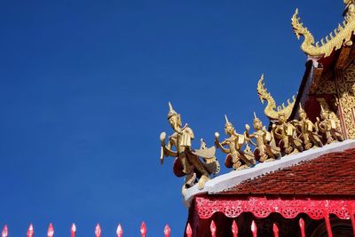 Low angle view of statue against blue sky