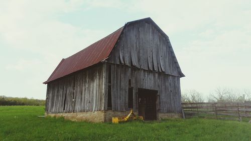 Barn on field against sky