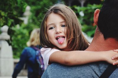 Father carrying playful daughter