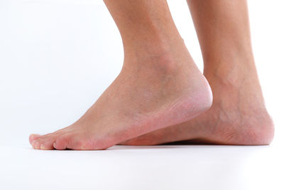 Low section of woman standing against white background