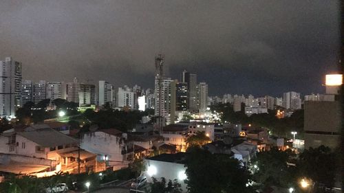 Illuminated cityscape against sky at night