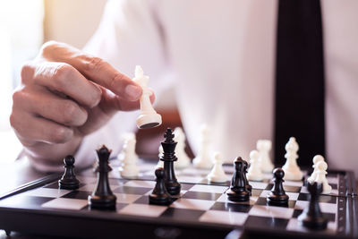 Midsection of businessman playing chess