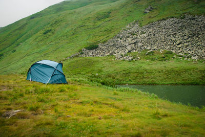 Scenic view of tent on field against mountain