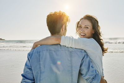 Portrait of happy woman with her partner on the beach