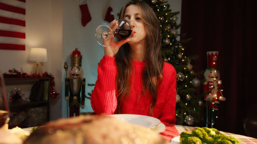 Girl drinking wine and cheering with the table set for thanksgiving