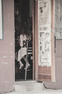 Rear view of woman standing by door