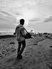 Rear view of man walking on beach