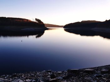 Scenic view of lake against clear sky during sunset