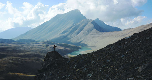 Silhouette person standing on mountain against sky