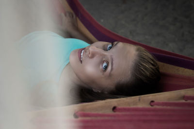 Close-up portrait of young woman lying down