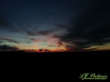 Silhouette landscape against dramatic sky during sunset