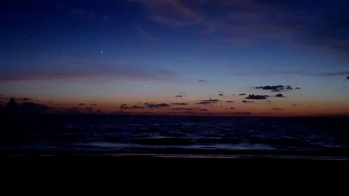 Silhouette of birds flying over sea