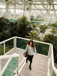 Full length of woman standing against plants