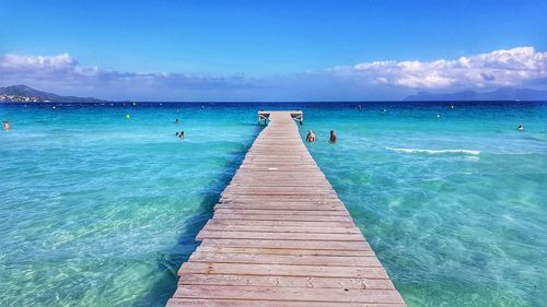 Pier over sea against blue sky