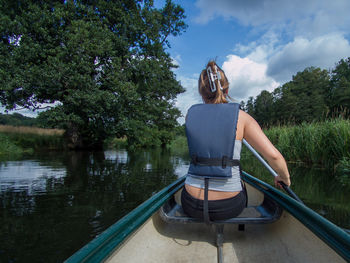Rear view of man standing by lake