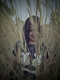 Close-up of young woman on grass in field