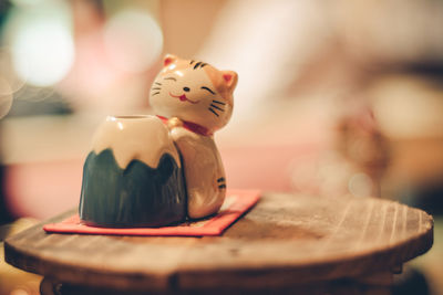 Close-up of cat figurine on table at coffee shop