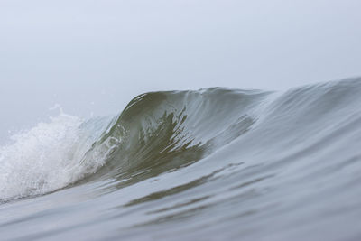 Close-up of sea waves splashing against clear sky