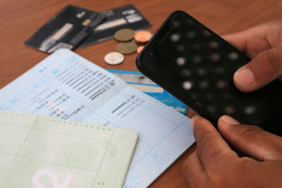 High angle view of person using mobile phone on table