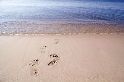 High angle view of footprints on sand at beach