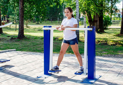 Full length of girl exercising on equipment in park