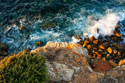 High angle view of rocks on sea shore