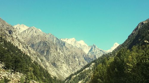 Low angle view of mountains against clear blue sky