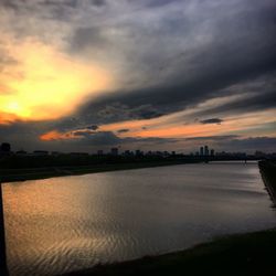 Scenic view of sea against cloudy sky at sunset