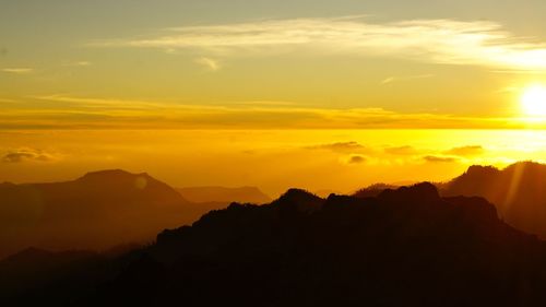 Scenic view of silhouette mountains against sky during sunset