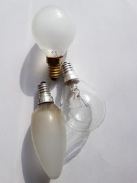 Directly above shot of various light bulbs on white table